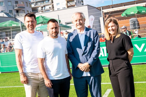 Vier Personen auf dem Fußballfeld von Rapid.