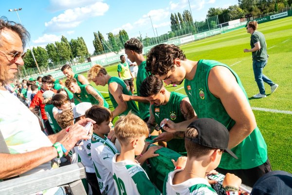 Rapid-Spieler geben jugendlichen Fans Autogramme.