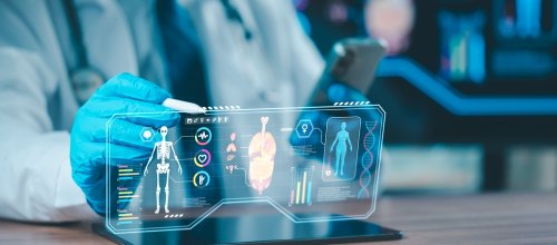 Ein Arzt sitzt vor einer Simulation und bemisst Körperdaten über ein Hologramm.