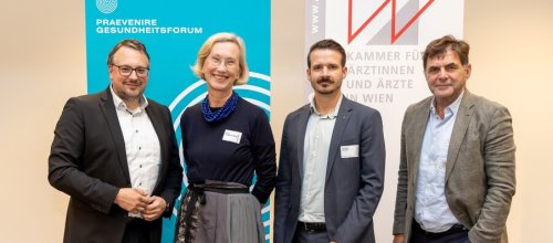 Drei Männer und eine Frau stehen