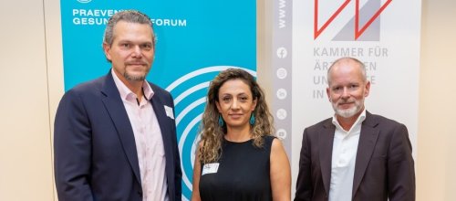 Drei Personen, zwei Männer und eine Frau, stehen beieinander.