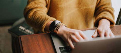 Frau sitzt an Laptop und arbeitet