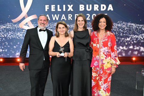 Ein Mann und drei Frauen stehen bei einer Preisverleihung auf der Bühne.