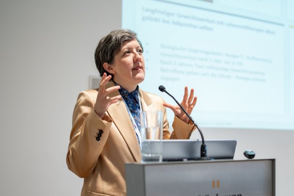 Die Wiener Ärztin Bianca-Karla Itariu steht am Rednerpult im Rahmen des Wiener Medizinischen Kongresses und hält beide Hände halbhoch - bis zur Schulter - während sie spricht und den Blick nach oben gerichtet hat.