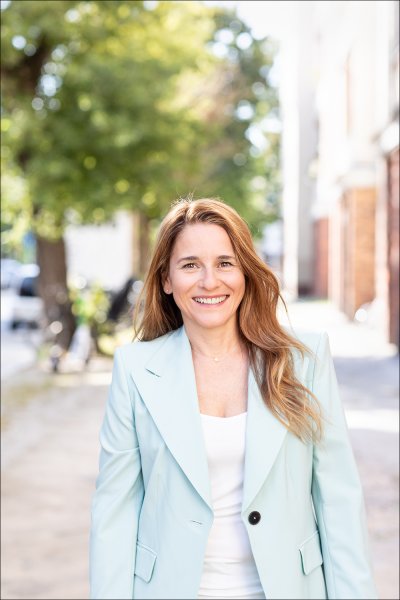 Porträt von lächelnder Frau in türkisem Blazer